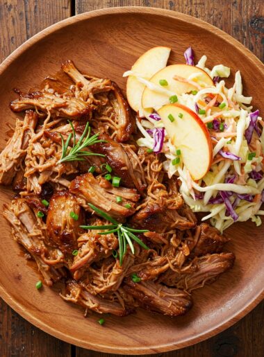 ender pulled pork served with fresh apple-cabbage slaw on a wooden plate